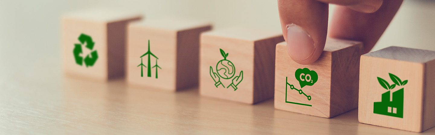 Net zero and carbon neutral concept. Net zero greenhouse gas emissions target. Climate neutral long-term strategy. Hand-laid wooden cubes with symbol for recycling, wind energy, climate protection, for the reduction of carbon emissions.